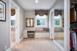 This luxurious master suite boasts a spacious walk-in closet with ample storage and built-in shelving.