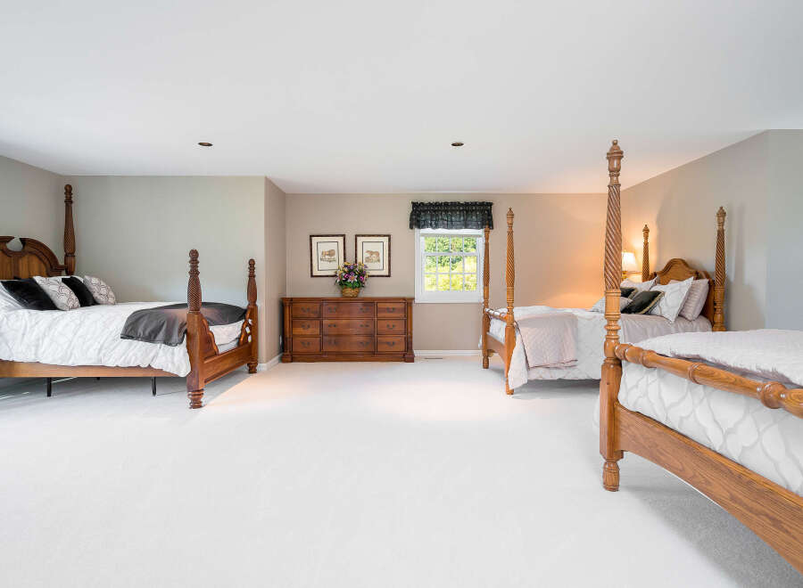 Spacious master bedroom with two poster beds and ample closet space.