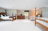 Spacious master bedroom with two poster beds and ample closet space.
