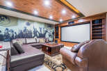 This luxurious home theater boasts a stunning wood-paneled ceiling and a large projection screen, perfect for movie nights.