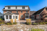 This stunning brick home boasts a spacious patio perfect for outdoor entertaining, complete with a flagstone walkway and lush landscaping.