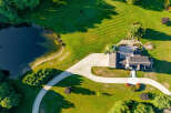This stunning property boasts a spacious house with a large, inviting driveway, perfectly situated on a lush green lawn.