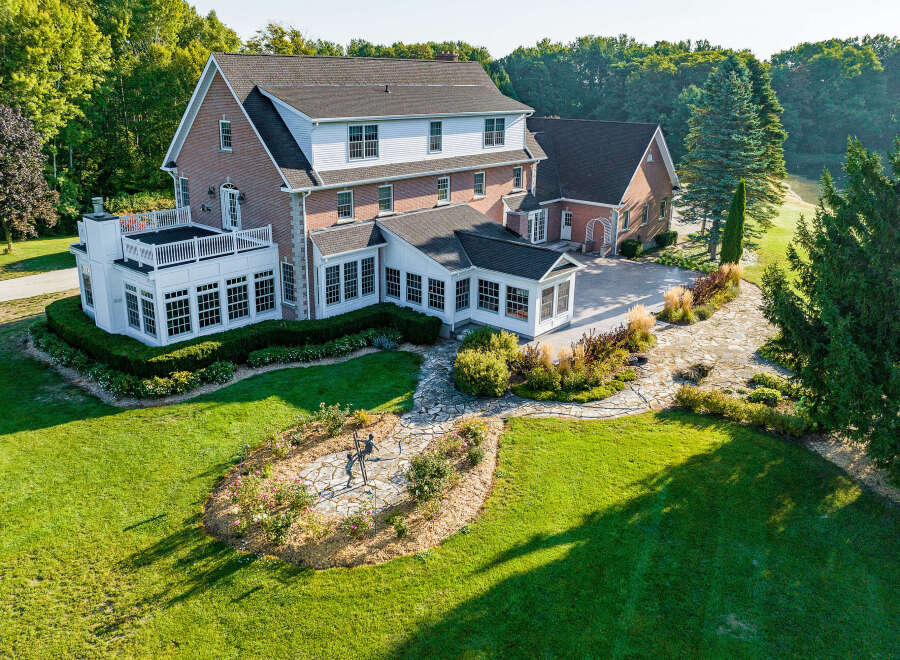 This stunning property boasts a spacious brick home with a large sunroom and expansive patio, perfect for outdoor entertaining.