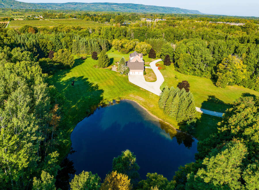 This stunning property boasts a spacious house with a three-car garage, nestled on a sprawling green lawn.