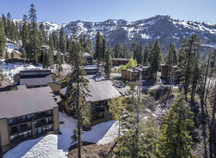 Luxury mountain condos nestled in a snowy landscape, offering breathtaking views of the majestic mountains.