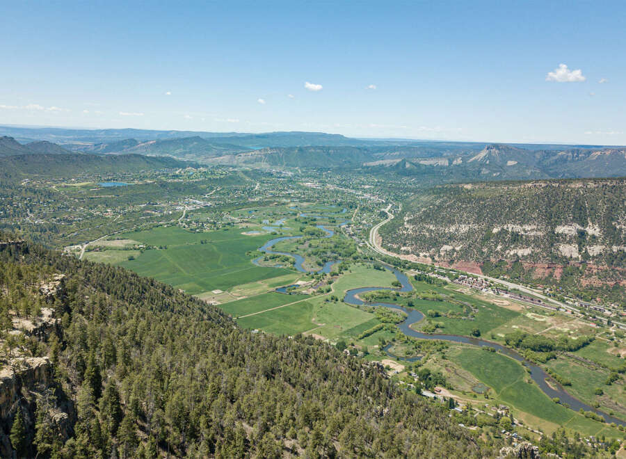 This stunning property boasts breathtaking panoramic views of the valley, river, and surrounding mountains.