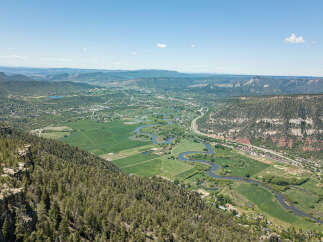 This stunning property boasts breathtaking panoramic views of the valley, river, and surrounding mountains.