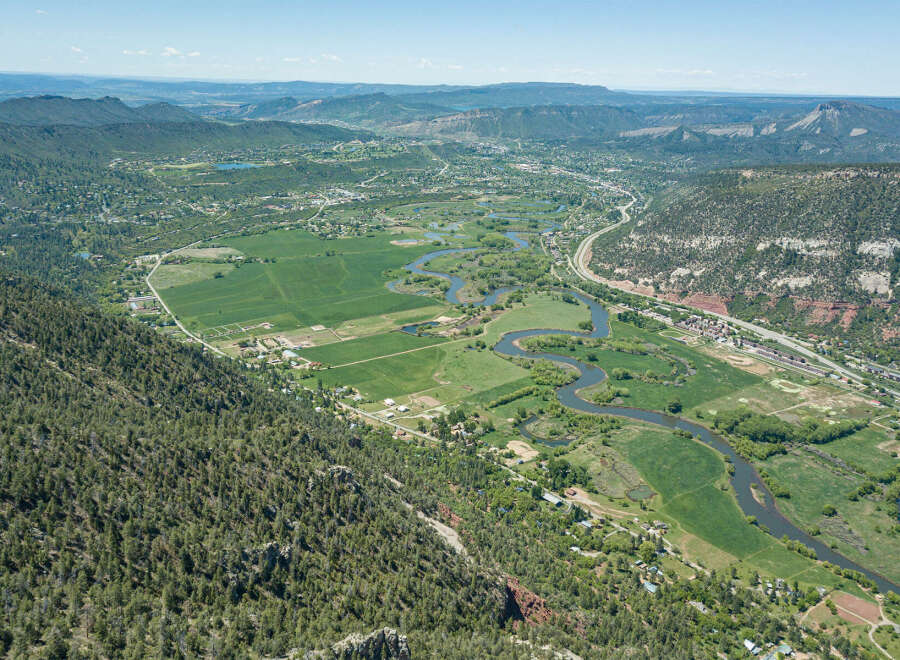 This stunning property boasts breathtaking panoramic views of a picturesque valley, complete with a meandering river and lush green fields.