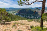Spectacular panoramic view of a lush valley from a rocky mountain peak.