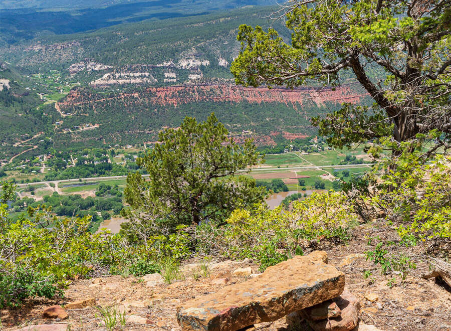 Enjoy breathtaking panoramic views of majestic mountains and valleys from this unique stone bench.