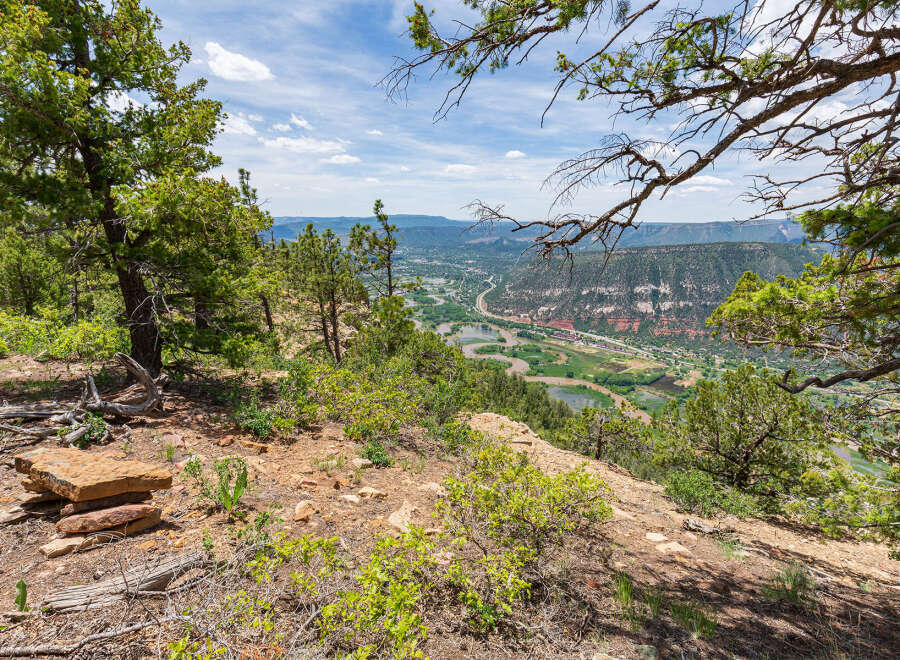 Spectacular panoramic views from this mountaintop property showcasing a lush valley and winding river.
