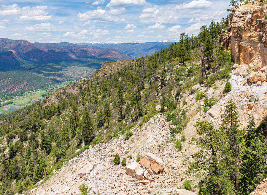 Spectacular mountain vista showcasing a dramatic cliffside, lush forests, and a valley below.