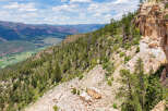 Spectacular mountain vista showcasing a dramatic cliffside, lush forests, and a valley below.