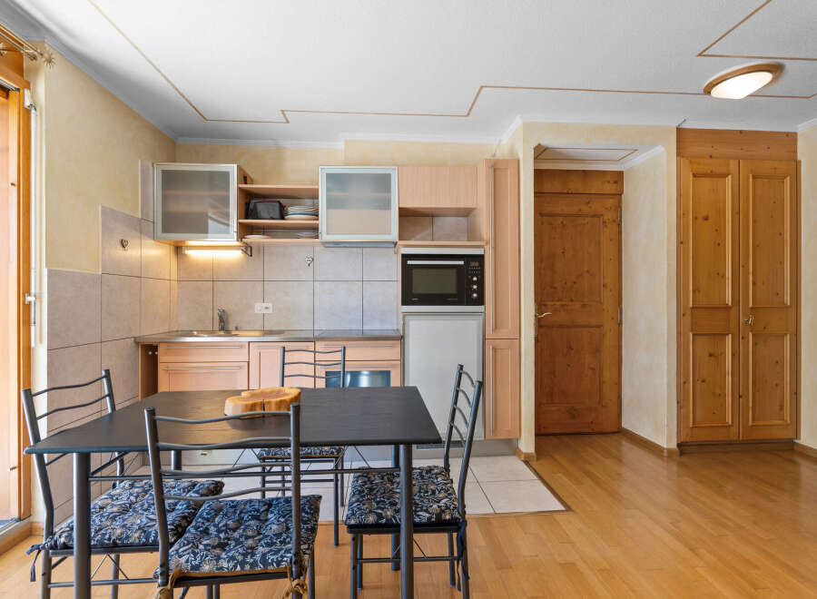 Cozy kitchen and dining area with modern appliances and wooden accents.