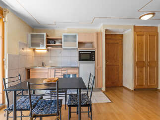 Cozy kitchen and dining area with modern appliances and wooden accents.