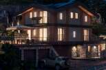This stunning modern home boasts a multi-level design with stone accents and sleek wooden features.