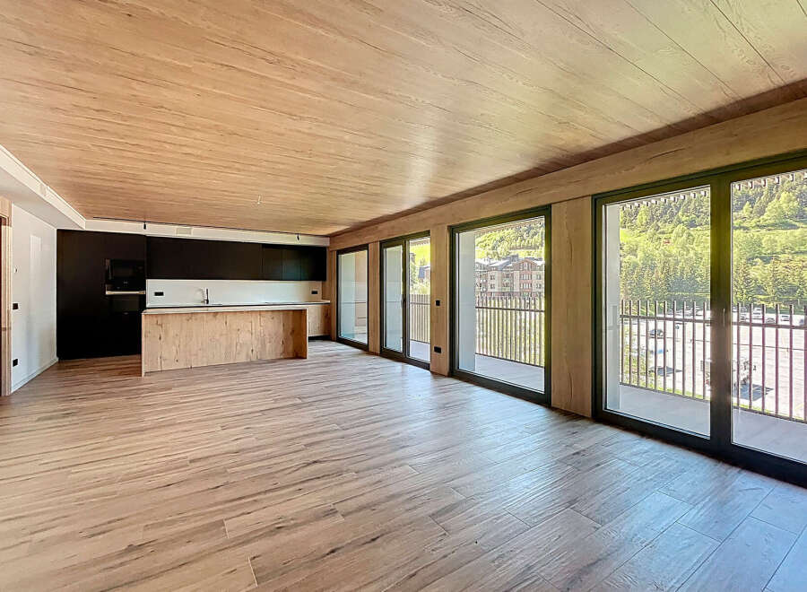Stunning open-plan living space with wood-effect flooring and ceiling, creating a warm and inviting atmosphere.