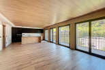 Stunning open-plan living space with wood-effect flooring and ceiling, creating a warm and inviting atmosphere.