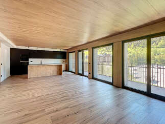 Stunning open-plan living space with wood-effect flooring and ceiling, creating a warm and inviting atmosphere.