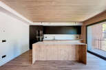 Modern kitchen with wooden island and dark cabinets.