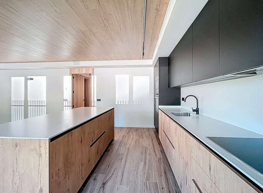 Stunning modern kitchen with sleek dark cabinets and light wood island.