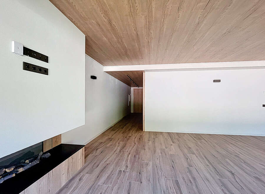 Modern living space featuring a sleek fireplace and wood-look flooring.