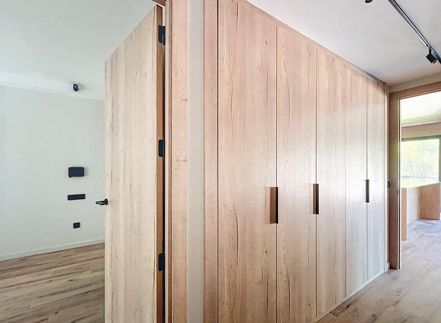 This stunning property boasts a modern design with sleek, light oak wood cabinetry and flooring.