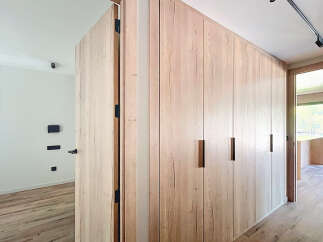 This stunning property boasts a modern design with sleek, light oak wood cabinetry and flooring.