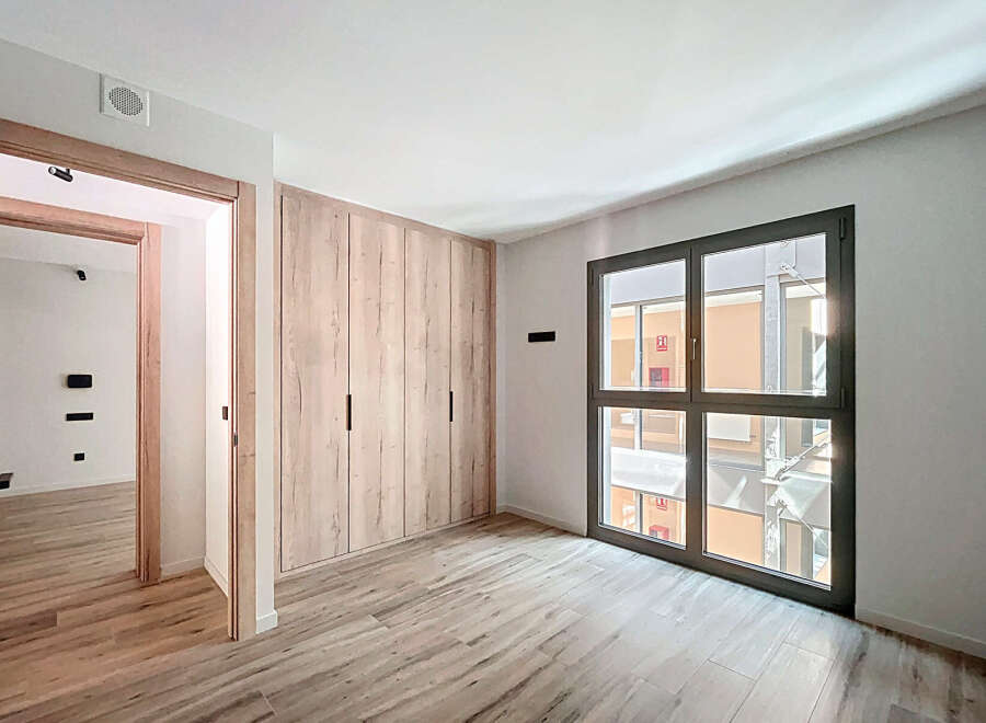 Bright and spacious bedroom with built-in wardrobe and large window offering ample natural light.