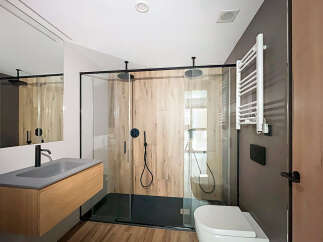 Modern bathroom with walk-in shower, sleek fixtures, and wooden vanity.