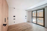 This stunning property boasts a spacious bedroom with sleek wooden flooring and large windows offering ample natural light.