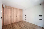 This stunning bedroom boasts a built-in wardrobe with light wood doors, offering ample storage space.