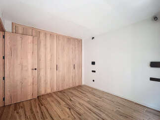 This stunning bedroom boasts a built-in wardrobe with light wood doors, offering ample storage space.