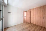 This stunning property boasts a spacious bedroom with sleek wooden flooring and built-in wardrobes.