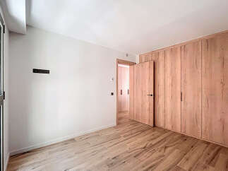This stunning property boasts a spacious bedroom with sleek wooden flooring and built-in wardrobes.