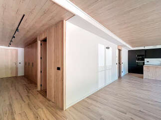 Stunning apartment boasts a spacious open-plan living area with sleek wooden flooring and a modern kitchen.