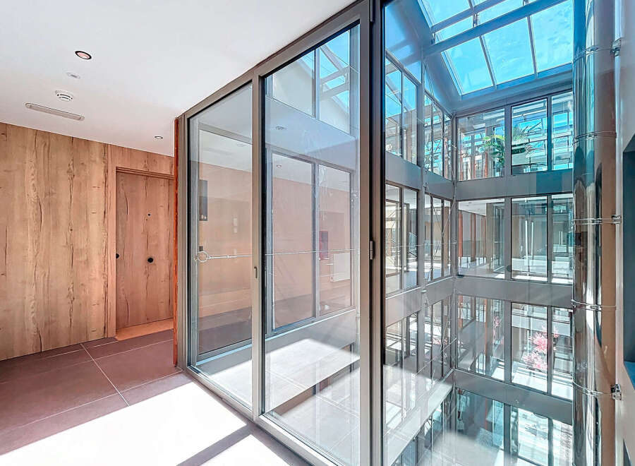 Modern apartment building with bright, airy hallways and floor-to-ceiling windows offering ample natural light.