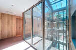 Modern apartment building with bright, airy hallways and floor-to-ceiling windows offering ample natural light.