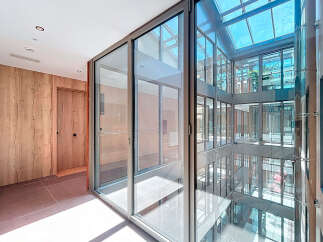 Modern apartment building with bright, airy hallways and floor-to-ceiling windows offering ample natural light.