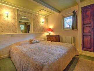 This charming bedroom features a cozy bed with a plush comforter, perfect for a relaxing retreat.