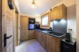 This stunning kitchen boasts a modern design with sleek black appliances and warm wood cabinetry.