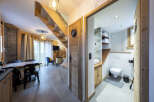 This stunning chalet boasts a spacious open-plan living area with a cozy seating arrangement and a modern kitchen.
