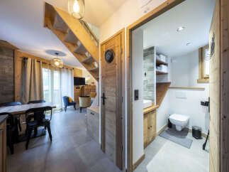 This stunning chalet boasts a spacious open-plan living area with a cozy seating arrangement and a modern kitchen.