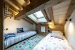 Charming attic bedroom with two twin beds, perfect for kids.