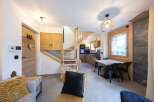 This stunning chalet boasts a spacious open-plan living area with a cozy seating arrangement and a modern kitchen.
