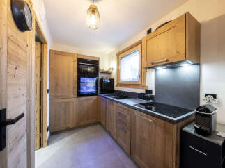 This stunning kitchen boasts a modern design with sleek black appliances and warm wood cabinetry.