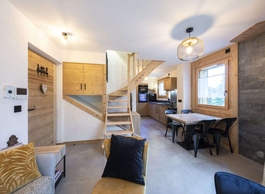 This stunning chalet boasts a spacious open-plan living area with a cozy seating arrangement and a modern kitchen.