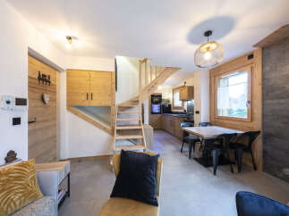 This stunning chalet boasts a spacious open-plan living area with a cozy seating arrangement and a modern kitchen.
