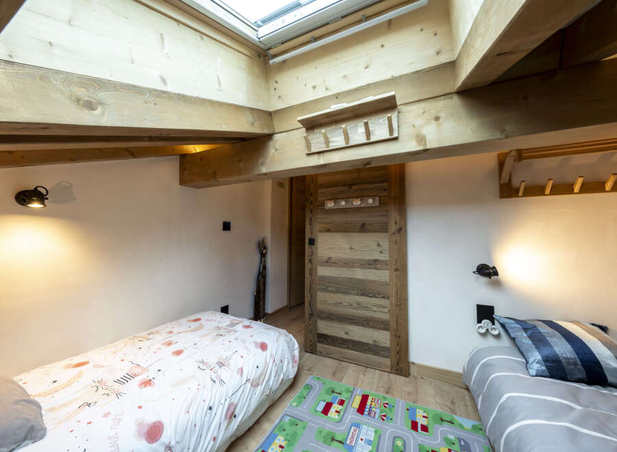 Charming attic bedroom with twin beds, perfect for kids.