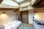 Charming attic bedroom with twin beds, perfect for kids.